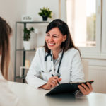 Young Doctor And Patient Talking In The Doctor's Office.